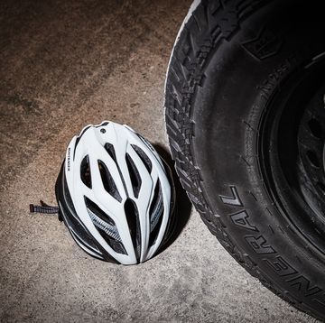 bicycling helmet in front of large truck tire