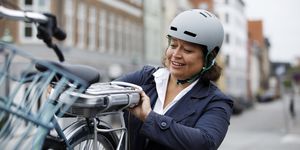 woman changing battery on electric bicycle