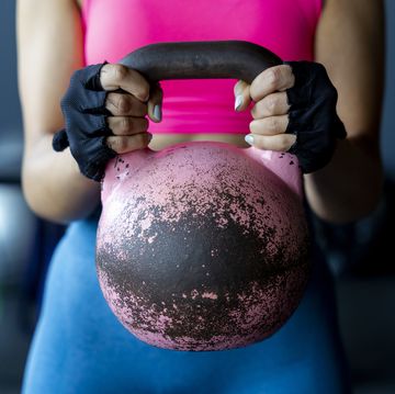 young female athlete holding kettlebell at gym